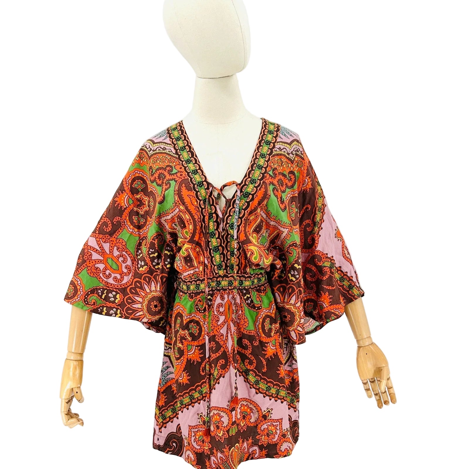 Colorful patterned dress on a mannequin against a white background