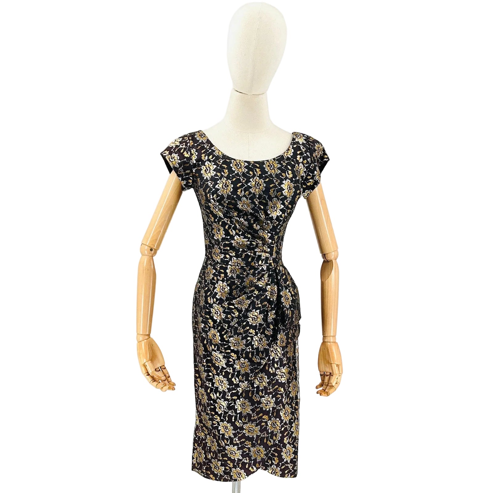 Black floral dress on a mannequin against a white background