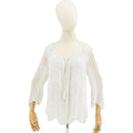White fringe garment on a mannequin against a white background
